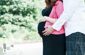 Expecting mommy and daddy holding maternity belly during maternity photography session